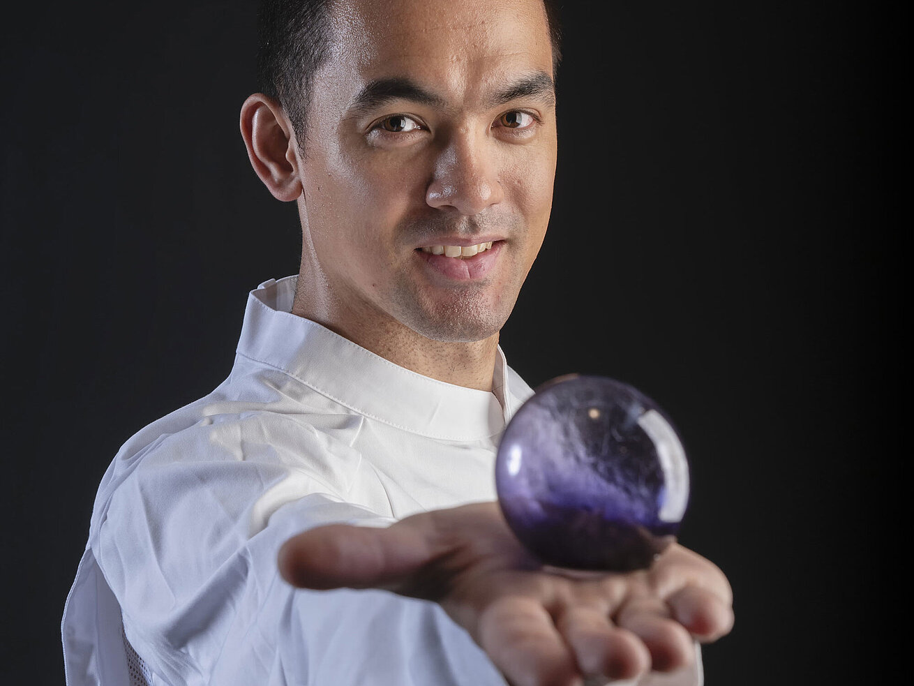 Chef Pâtissier Taro Bünemann Chef Pâtissier Taro Bünemann in der Orangerie im Maritim Hotel Timmendorfer Strand, hält eine violette Kugel in der Hand.