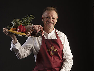 Küchenchef Thomas Lemke Küchenchef Thomas Lemke trägt ein Tablett mit Gemüse und Fleisch in der Orangerie im Maritim Hotel Timmendorfer Strand.