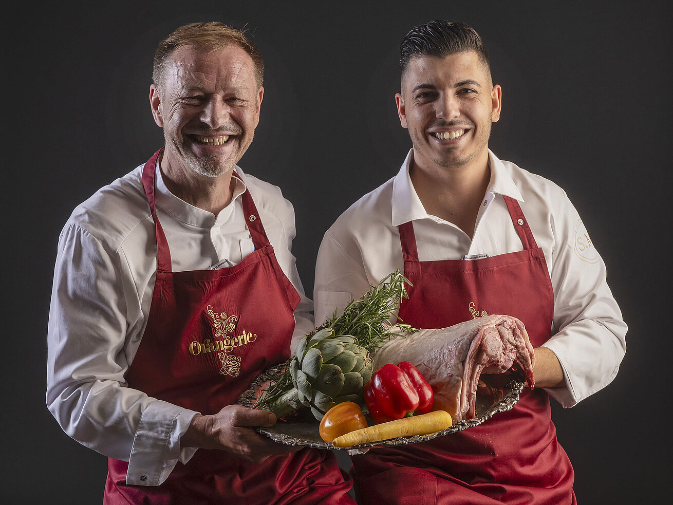 Küchenchefs Simone Melis und Thomas Lemke Küchenchefs Simone Melis und Thomas Lemke präsentieren ein Tablett mit Gemüse und Fleisch in der Orangerie des Maritim Hotels