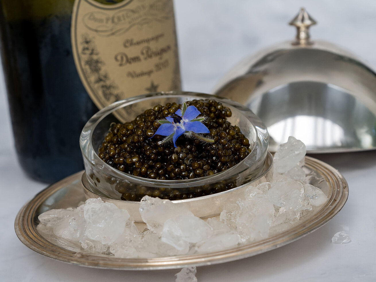 Kaviar Feiner Kaviar stilvoll serviert auf Eis mit Silberhaube im Sternerestaurant Orangerie.