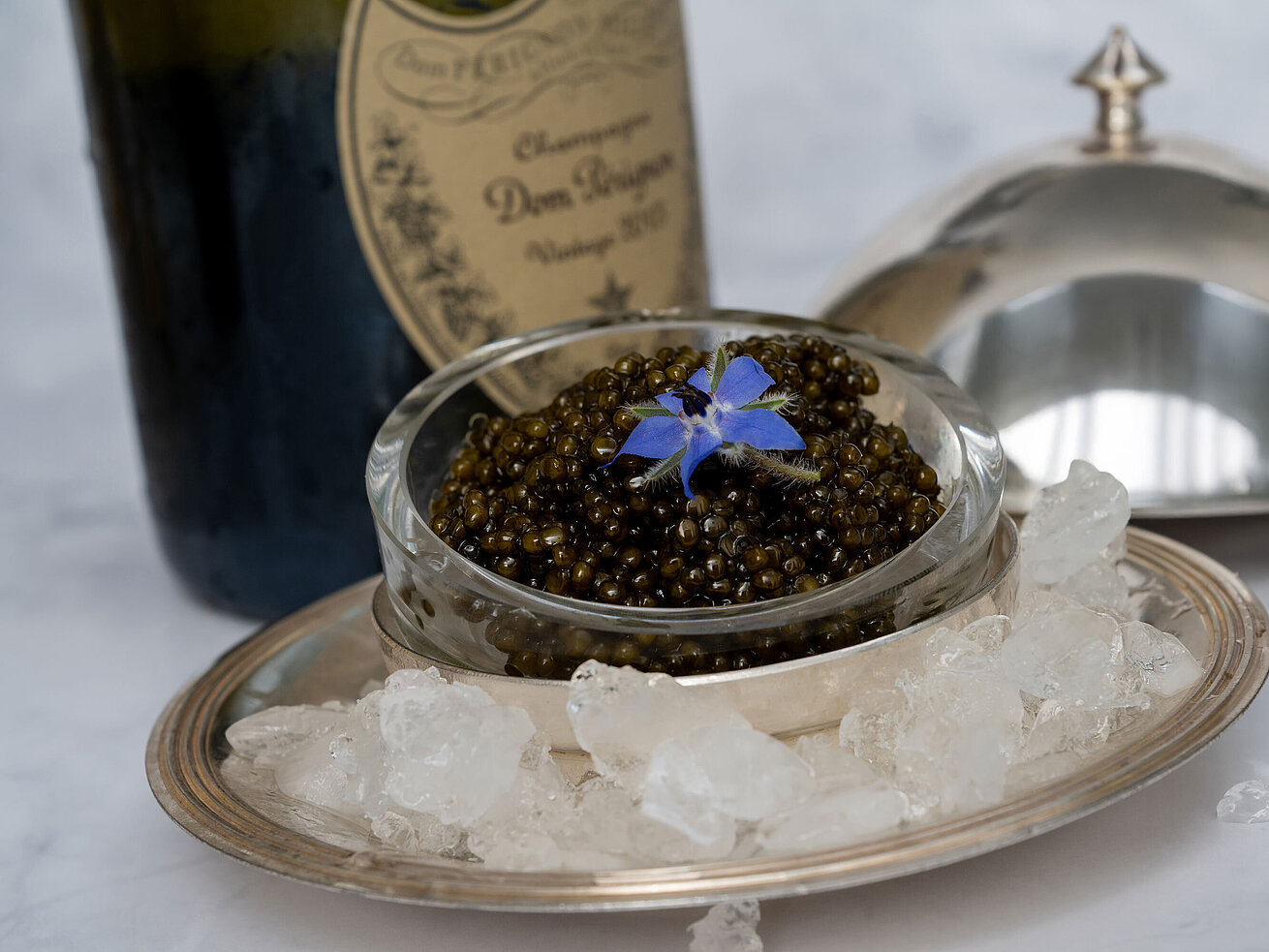 Kaviar Feiner Kaviar stilvoll serviert auf Eis mit Silberhaube im Sternerestaurant Orangerie.