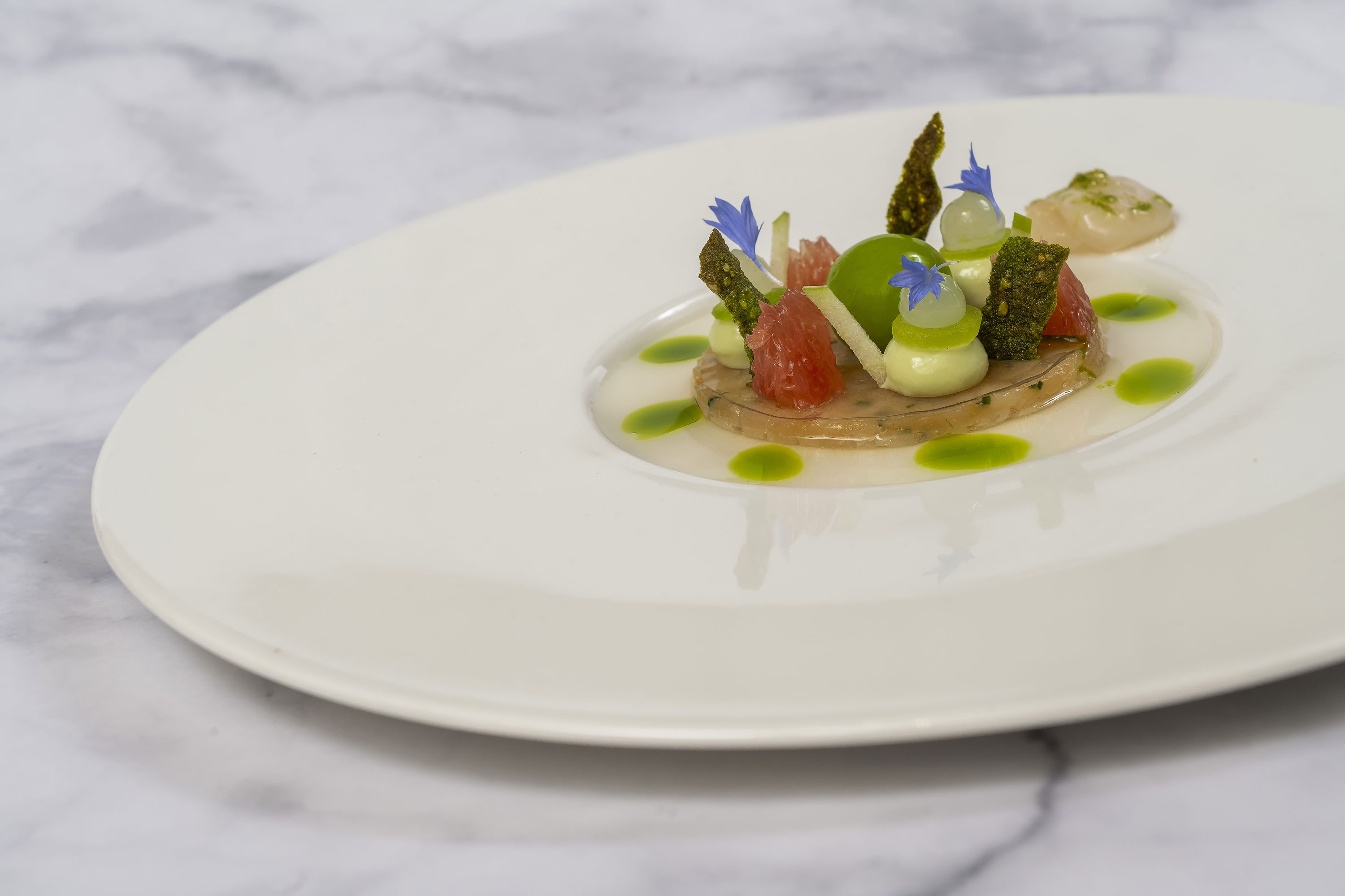 Gericht mit Jakobsmuscheln Gericht mit Jakobsmuscheln und kunstvoller Präsentation in der Orangerie im Maritim Hotel Timmendorfer Strand.