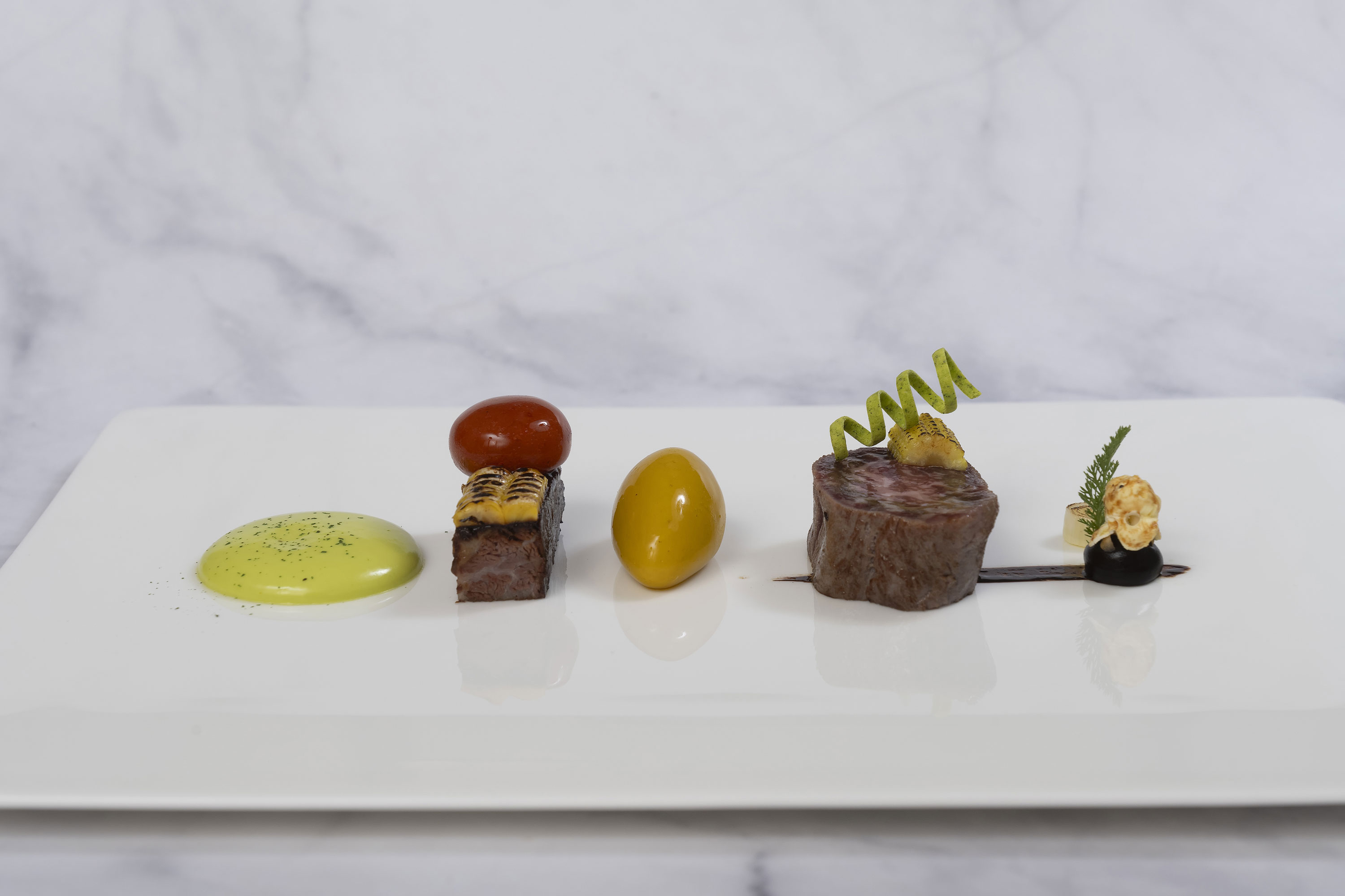 Wagyu Gericht Wagyu-Gericht in der Orangerie im Maritim Hotel Timmendorfer Strand, kreativ angerichtet auf weißem Teller.
